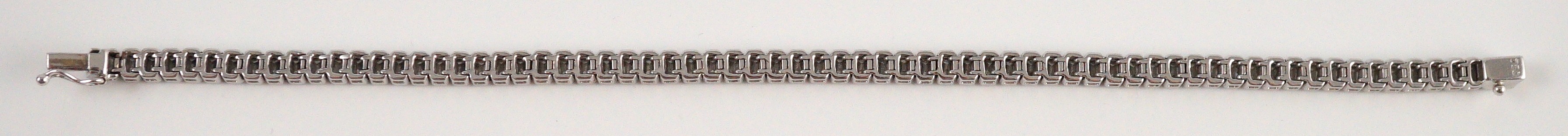 A modern 18ct white gold and emerald cut diamond set line bracelet